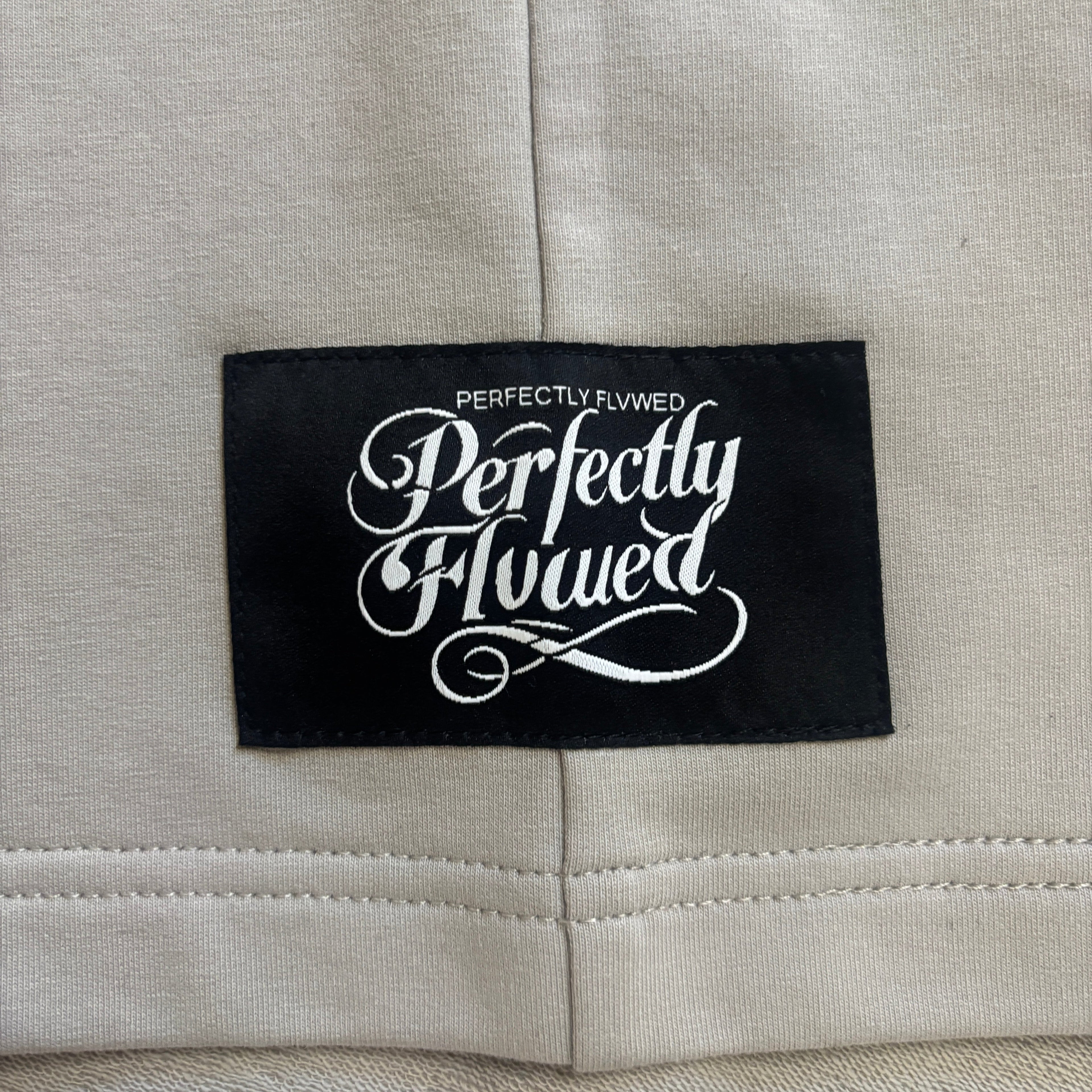 Label with 'Perfectly Flewed' text on a gray fabric background